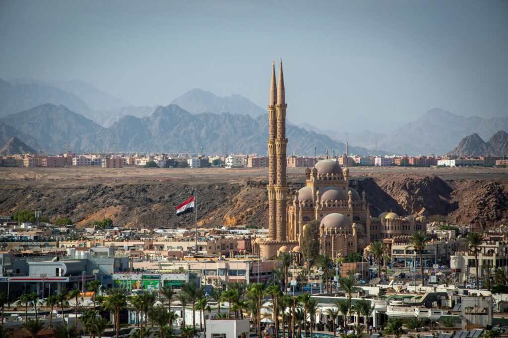 A stunning aerial view of Al Sahaba Mosque against Sharm El Sheikh cityscape and mountains.